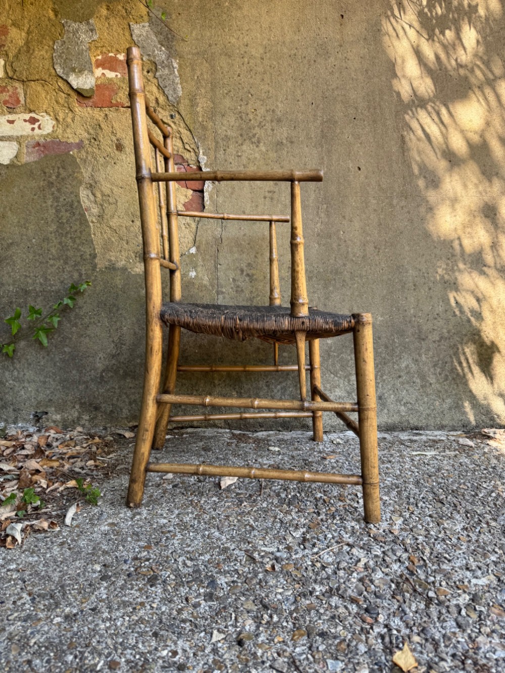 An antique turned wooden armchair with faux-bamboo detailing and a dark woven rush seat. View XI