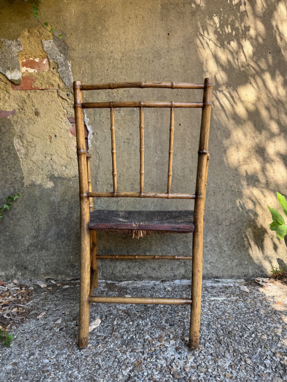An antique turned wooden armchair with faux-bamboo detailing and a dark woven rush seat. View XII