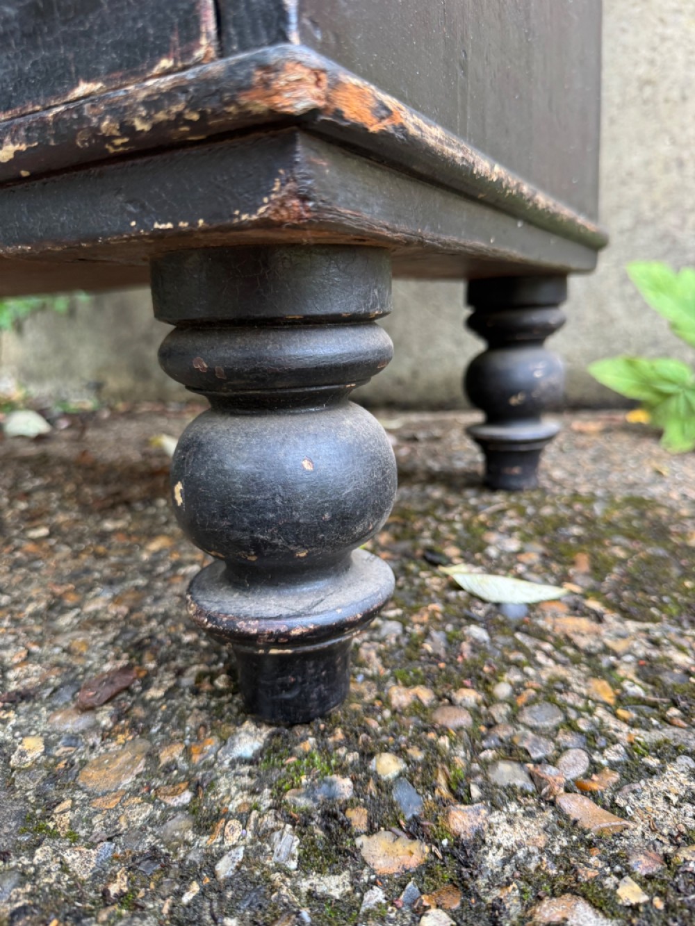 A Victorian dark painted pine chest featuring two short drawers above three long drawers, fitted with turned wooden knobs and supported by turned feet. View VI