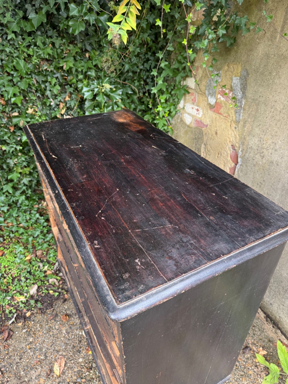 A Victorian dark painted pine chest featuring two short drawers above three long drawers, fitted with turned wooden knobs and supported by turned feet. View XIII