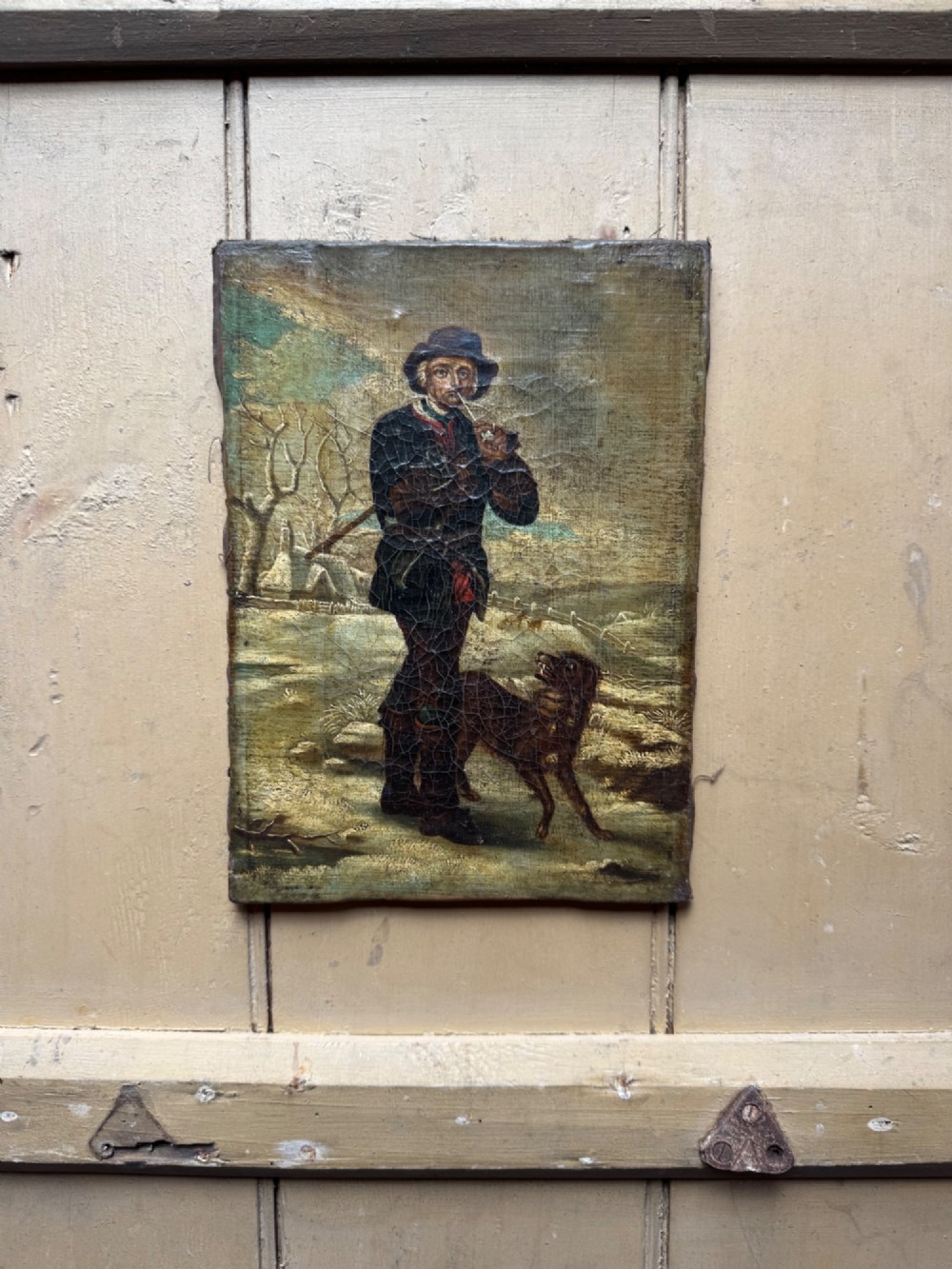An antique oil painting depicting a standing man with a pipe and his dog in a countryside landscape, housed in a deep silvered moulded frame. View VII