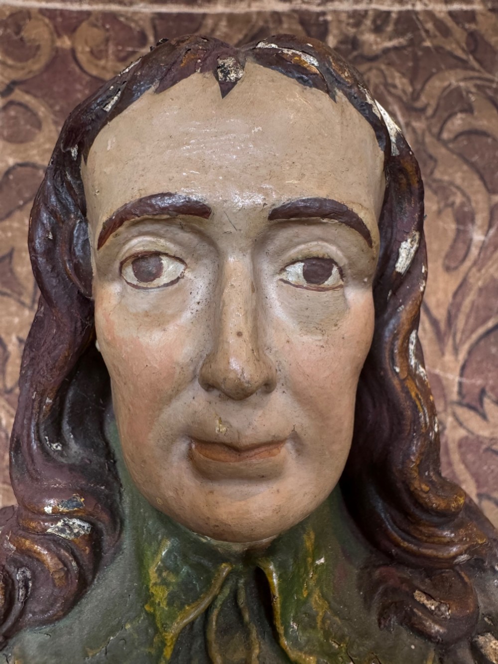 A polychrome painted bust depicting John Milton with long brown hair, a collared shirt with tassels, and a grey socle pedestal base. View XI