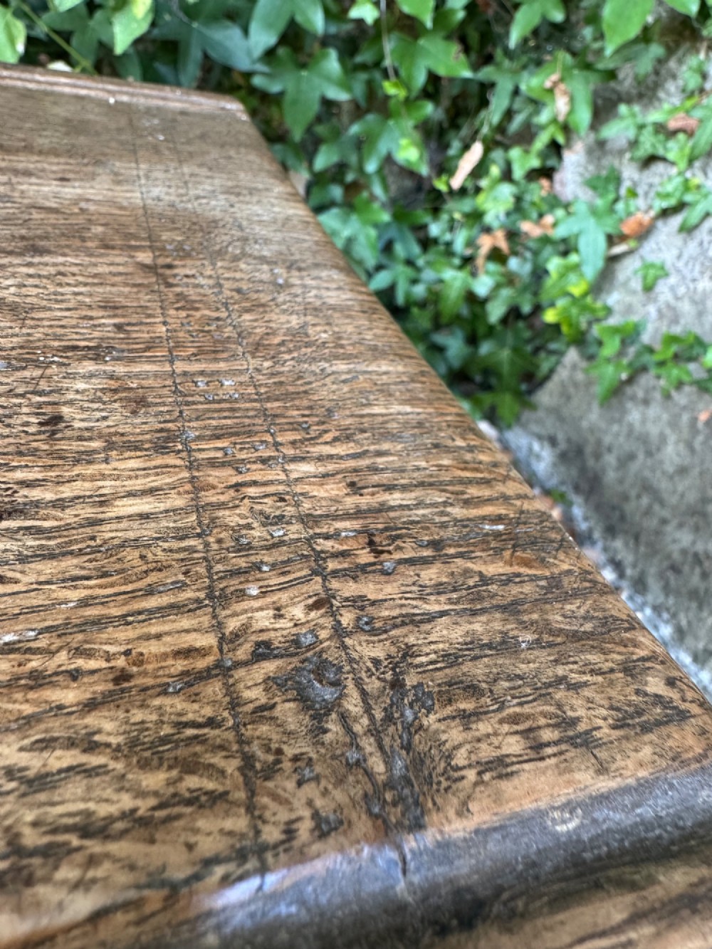 An early oak plank coffer featuring notched end panels, a hinged lid, horizontal moulding, and an iron lockplate. View VII