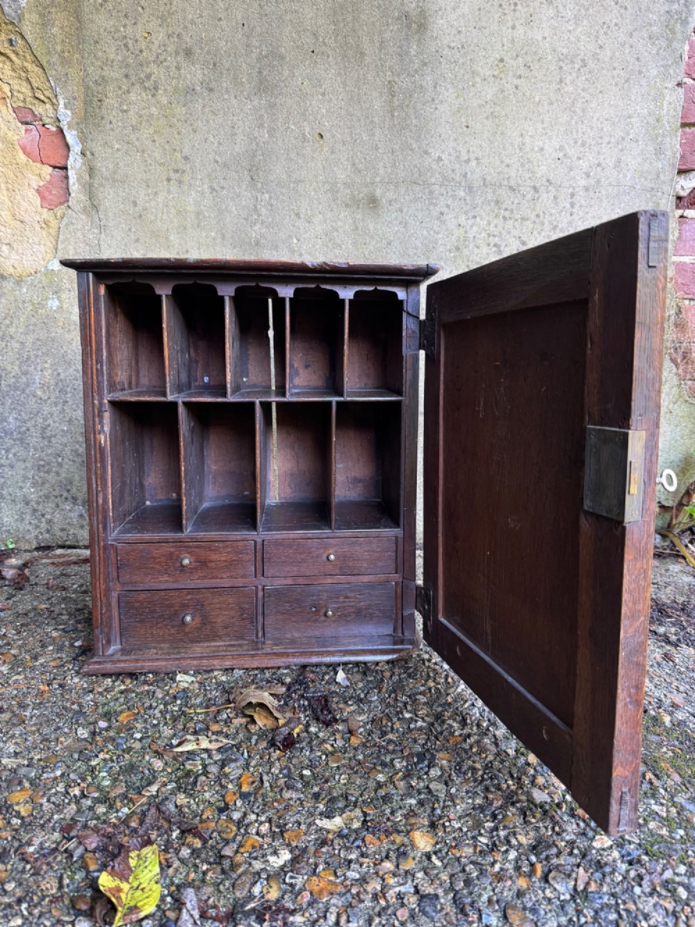 A small dark oak cupboard featuring a single fielded panel door with a brass keyhole escutcheon. View IV