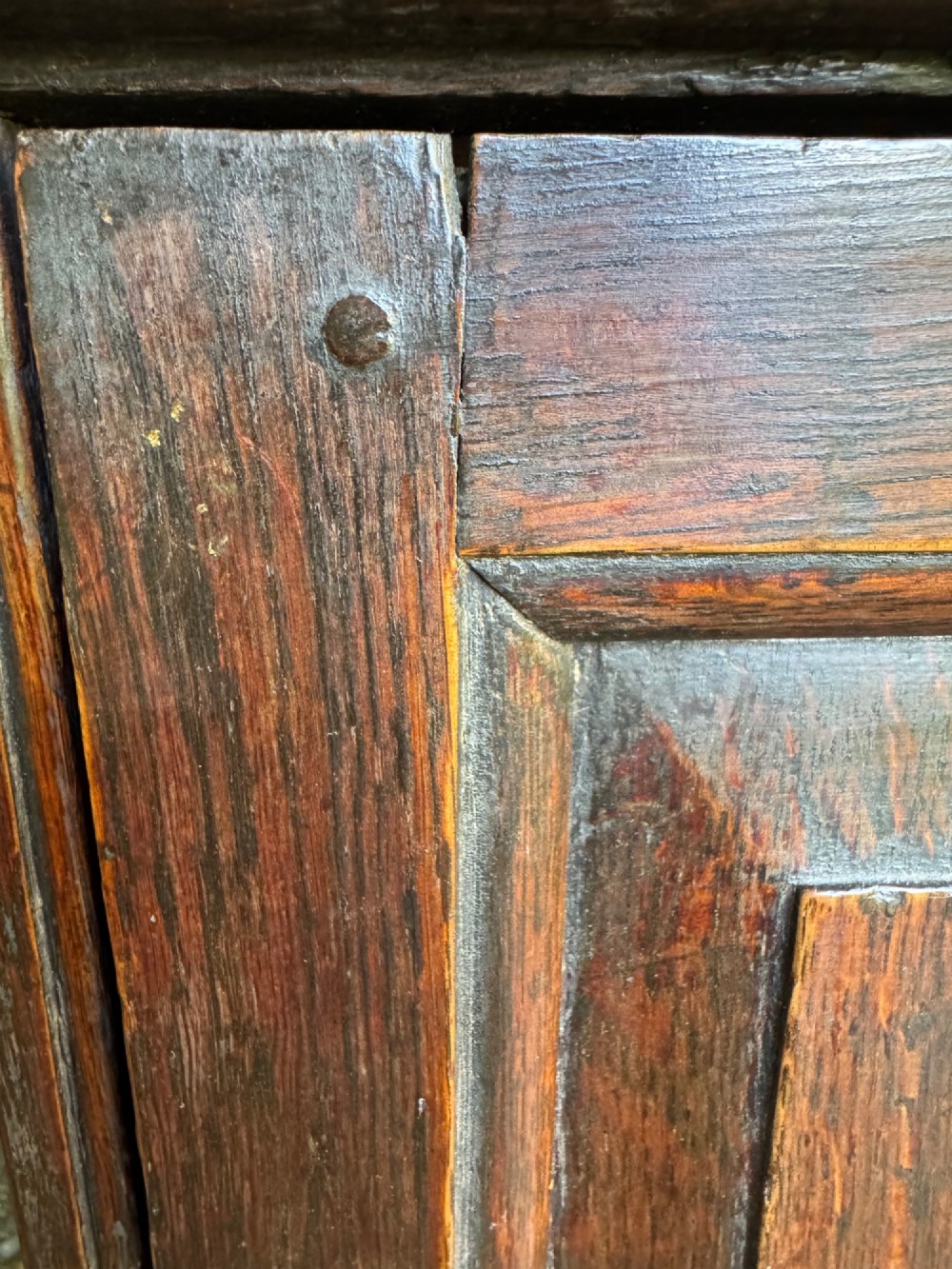 A small dark oak cupboard featuring a single fielded panel door with a brass keyhole escutcheon. View VII