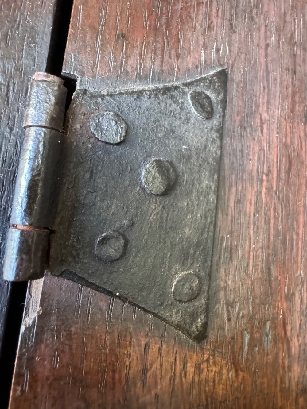 A small dark oak cupboard featuring a single fielded panel door with a brass keyhole escutcheon. View XII