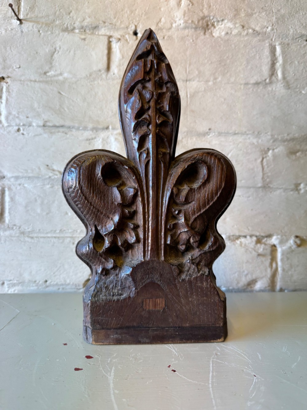 A hand-carved dark oak poppy head finial featuring intricate Gothic leaf motifs standing vertically. View II