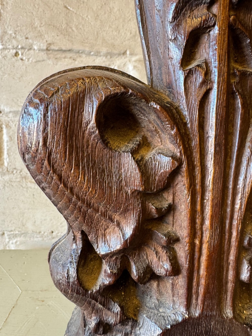 A hand-carved dark oak poppy head finial featuring intricate Gothic leaf motifs standing vertically. View VI