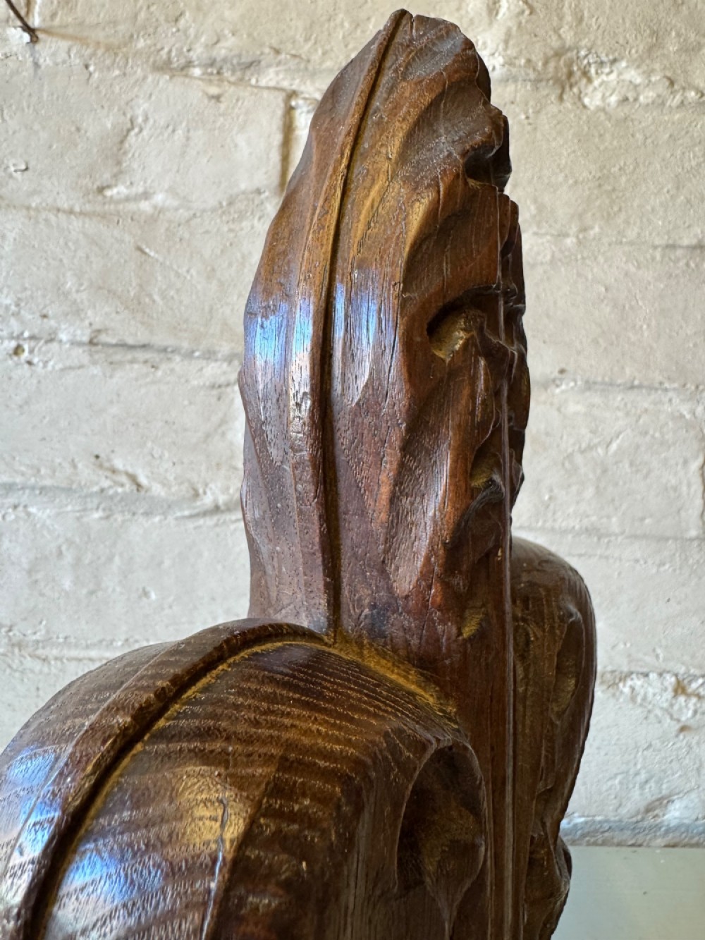 A hand-carved dark oak poppy head finial featuring intricate Gothic leaf motifs standing vertically. View VIII