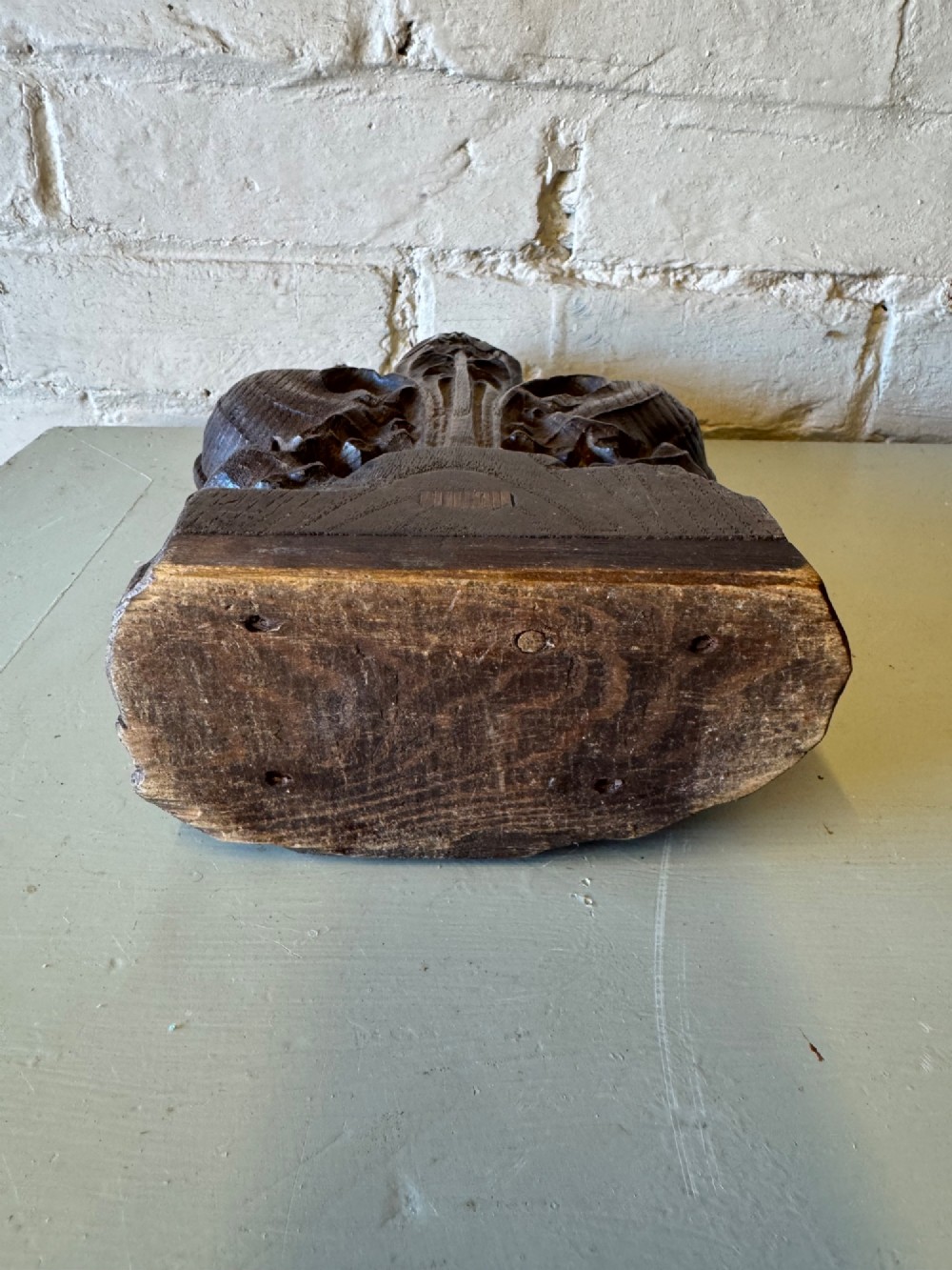 A hand-carved dark oak poppy head finial featuring intricate Gothic leaf motifs standing vertically. View IX