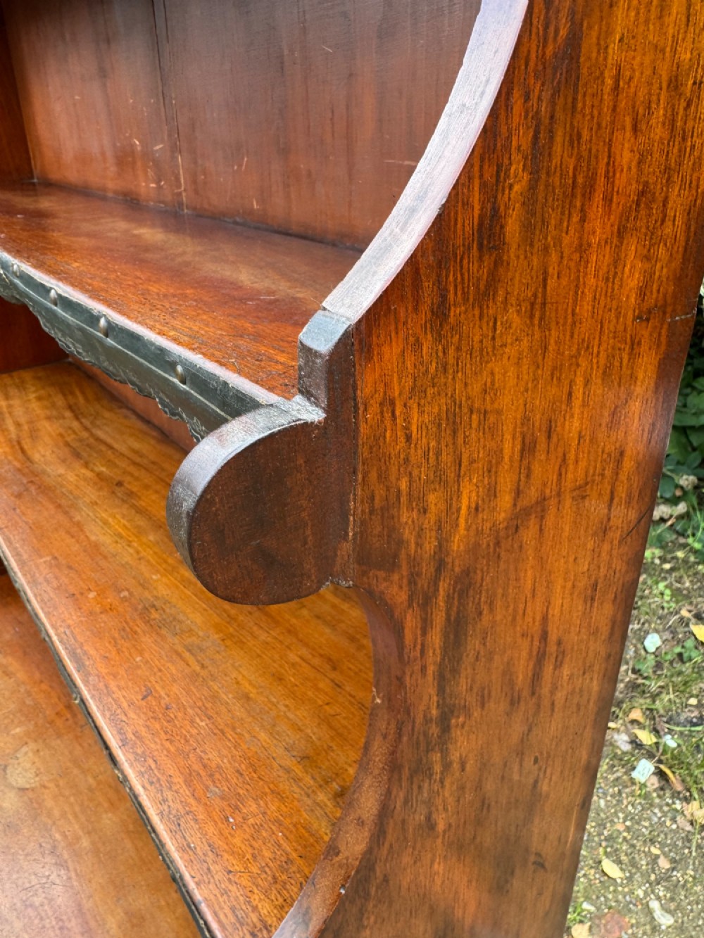 An antique mahogany waterfall bookcase featuring four open graduated shelves with dark trim above two lower drawers with turned wood knobs. View VIII