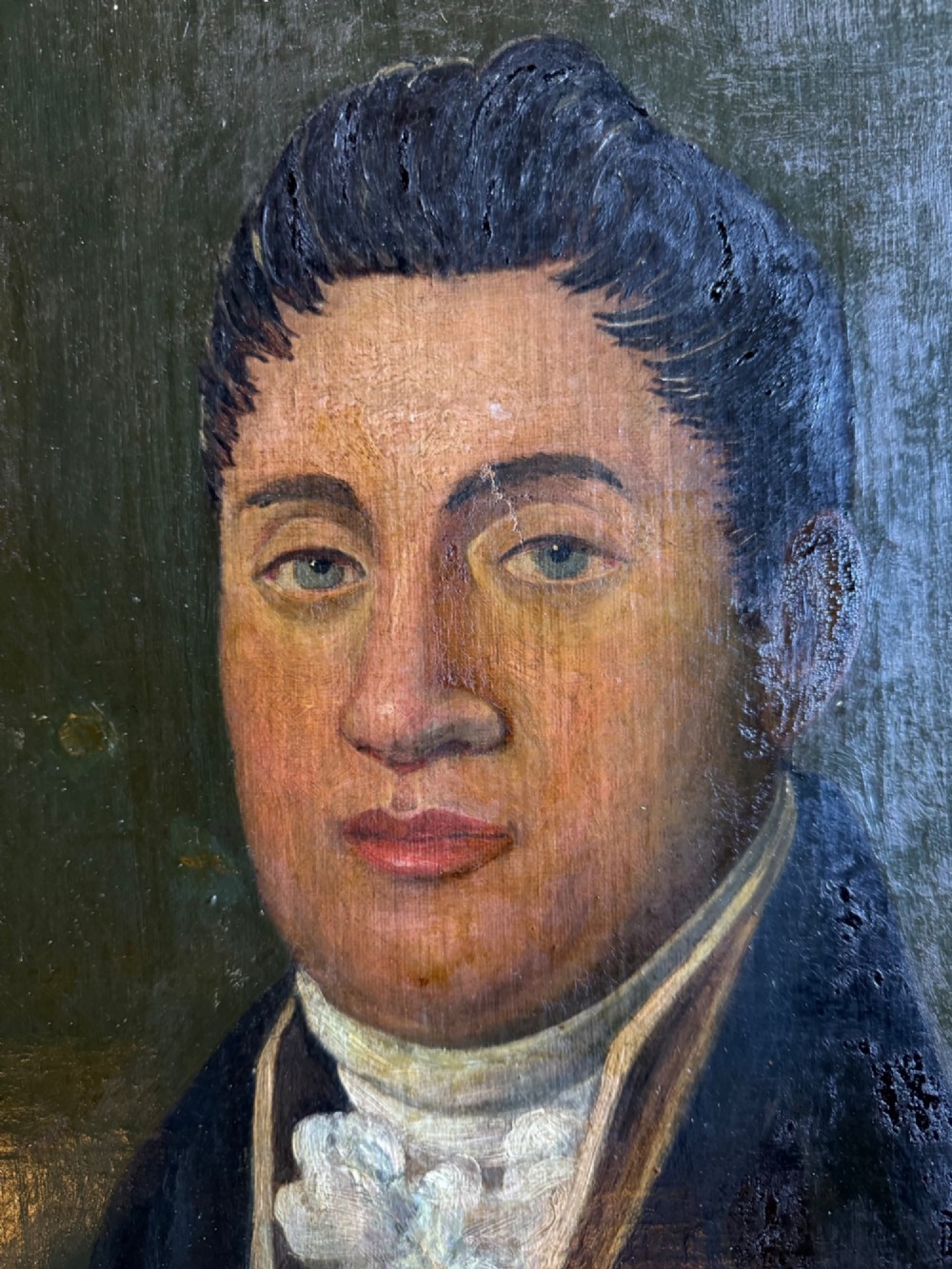 An antique oil painting depicting a gentleman in a dark double-breasted coat and white cravat, set within an ornate gold giltwood frame. View IV