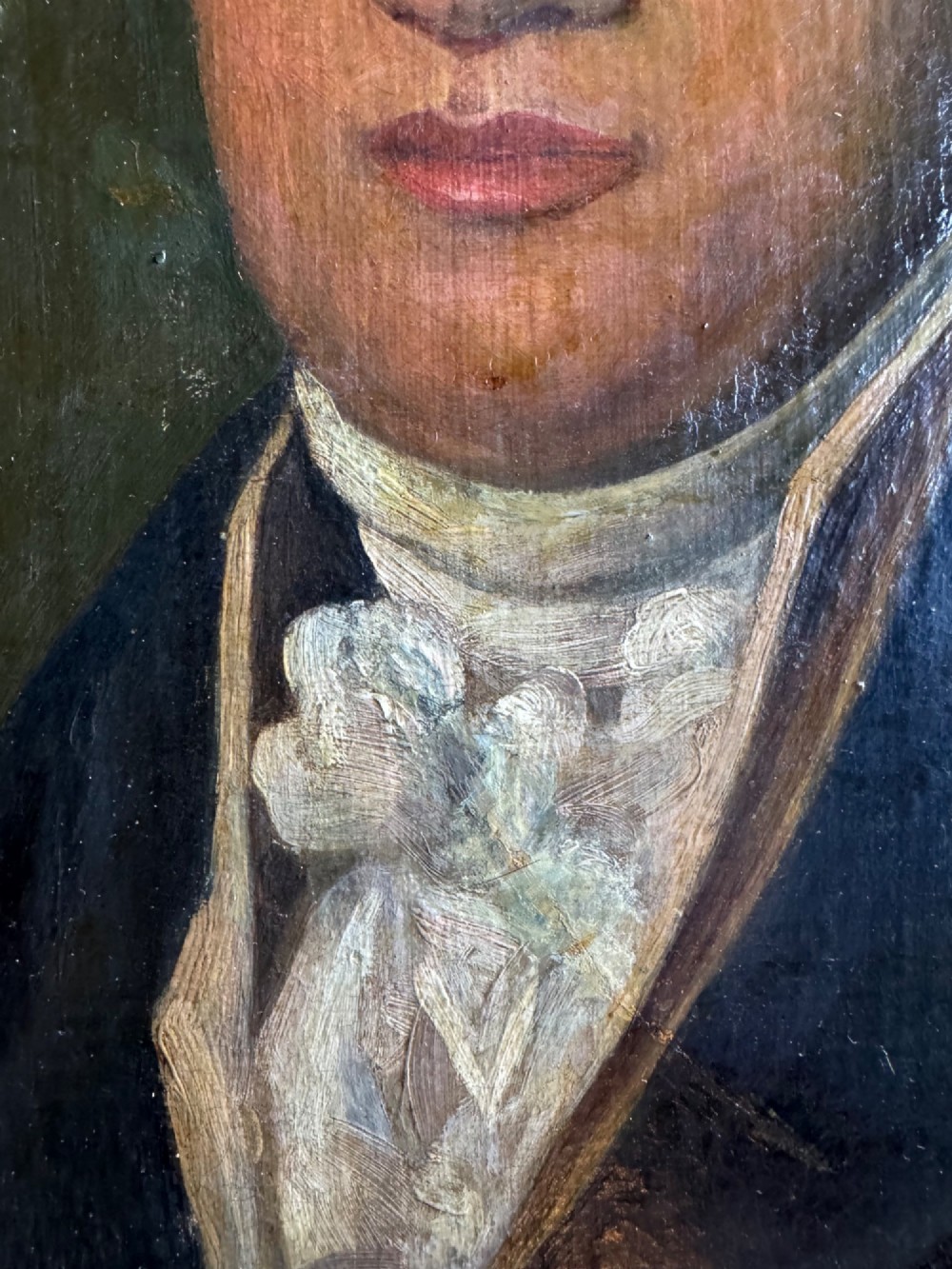 An antique oil painting depicting a gentleman in a dark double-breasted coat and white cravat, set within an ornate gold giltwood frame. View V