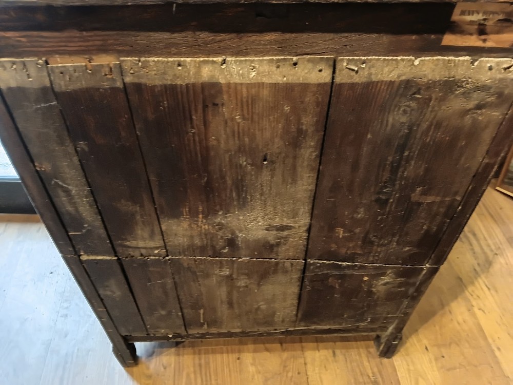 An antique brown oak chest of drawers featuring three small upper drawers over three long graduated drawers with brass drop handles. View V
