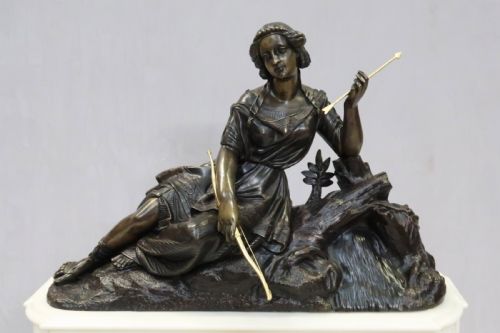fig 3. An antique French Napoleon III mantel clock featuring a dark patinated bronze figure of Diana the Huntress holding a bow, set atop a rectangular white marble base with gilt-bronze mounts.