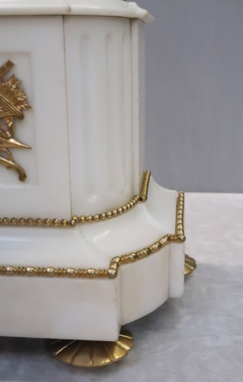 fig 4. An antique French Napoleon III mantel clock featuring a dark patinated bronze figure of Diana the Huntress holding a bow, set atop a rectangular white marble base with gilt-bronze mounts.