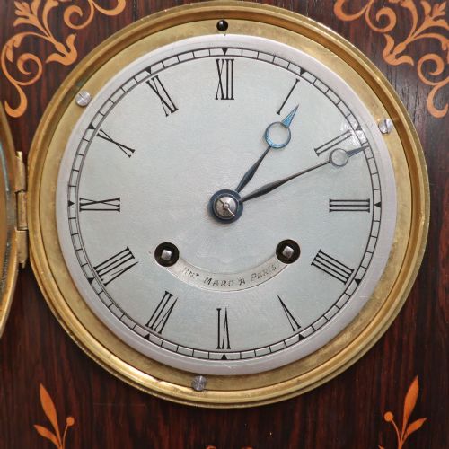 fig 2. A nineteenth-century rectangular dark rosewood mantel clock featuring foliate marquetry inlay, a brass-rimmed circular dial with Roman numerals, and a stepped plinth base.