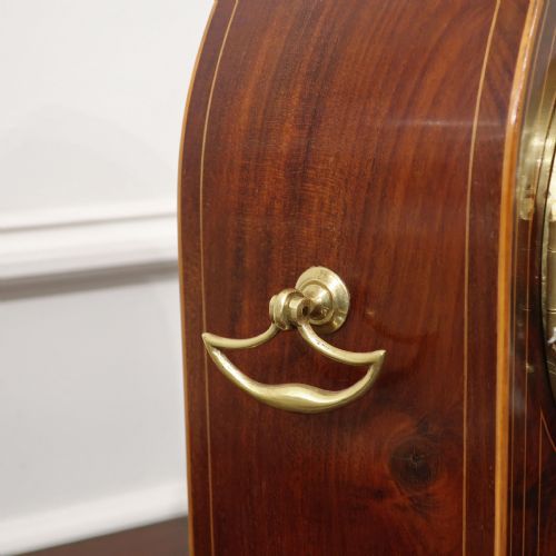 fig 2. A French Belle Epoque arched mahogany mantel clock featuring a white enamel dial, brass bezel, and fine stringing inlay.