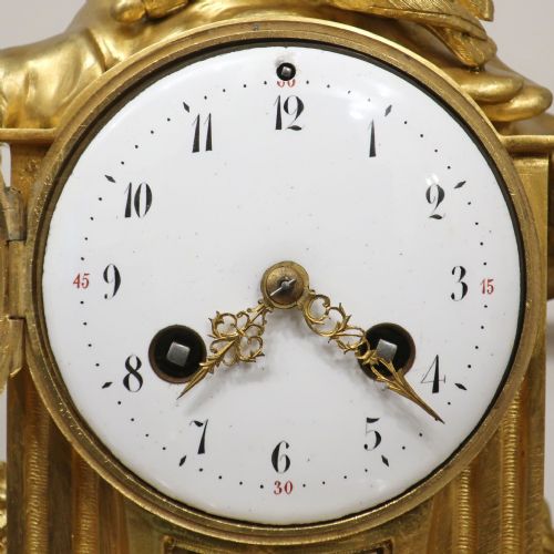 fig 2. A French Louis XVI style gilt bronze and white marble mantel clock featuring a pair of sculpted doves atop a circular enamel dial flanked by fluted pillars.