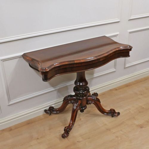 fig 1. A Victorian dark brown rosewood side table featuring a serpentine top, central turned column, and four carved scroll legs.