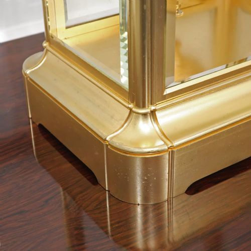 fig 3. A rectangular French gilt brass mantel clock featuring four bevelled glass panels, an exposed pendulum, and a white enamel dial with Roman numerals.