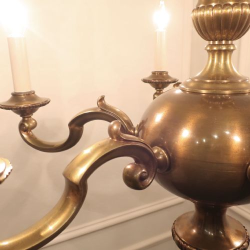 fig 3. An Edwardian brass six-arm chandelier hanging from a link chain, featuring curved S-scroll branches and candle-style bulb holders.