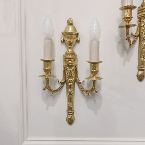 fig 1. A pair of French Louis XVI style gilt bronze twin arm wall lights featuring classical urn finials and ribbon relief decorations.