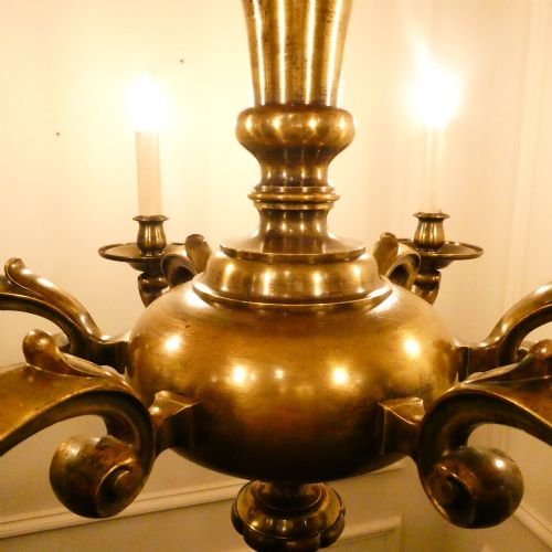 fig 2. An Edwardian six-light aged brass chandelier featuring a central turned baluster shaft, scrolled arms, and candle sleeves.