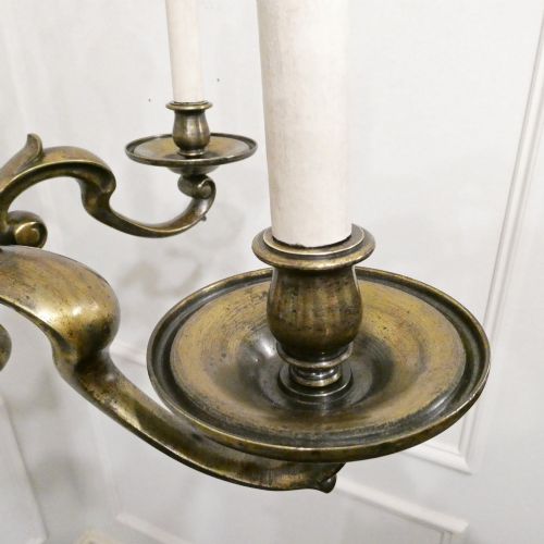 fig 4. An Edwardian six-light aged brass chandelier featuring a central turned baluster shaft, scrolled arms, and candle sleeves.