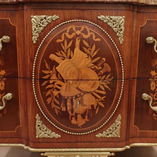 fig 1. A French Louis XVI style marquetry chest of drawers featuring inlaid central medallion motifs, gilded bronze handles, tapered legs, and a fitted marble top.