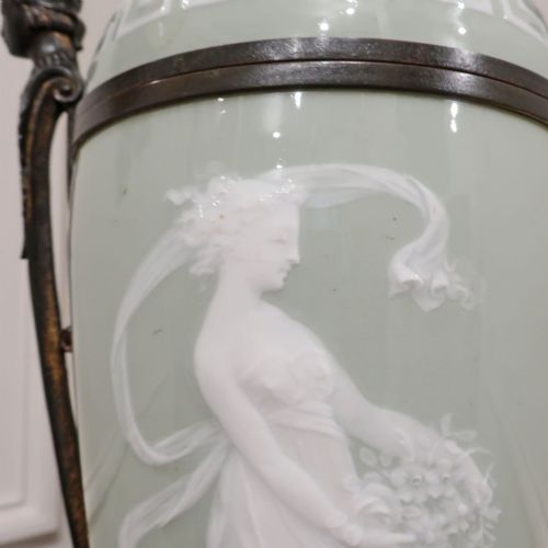 fig 2. A French Neoclassical style table lamp featuring a pale green pate-sur-pate porcelain urn base, dark bronze side handles, and a pleated cream shade.
