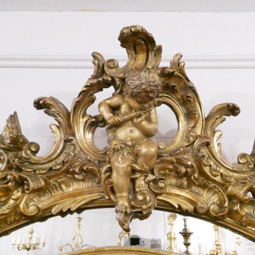 fig 2. A 19th-century French Louis XVI style gilded wall mirror featuring a carved decorative crest and beaded frame border.