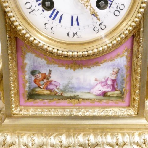 fig 2. A Louis XVI style gilt bronze mantel clock featuring hand-painted pink porcelain panels and an urn-shaped finial.