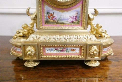 fig 3. A Louis XVI style gilt bronze mantel clock featuring hand-painted pink porcelain panels and an urn-shaped finial.