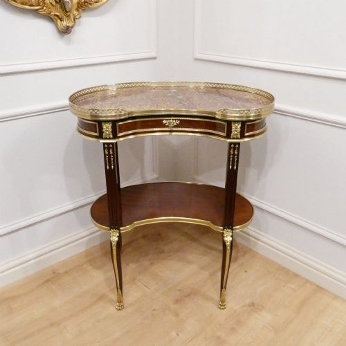 fig 1. A French Louis XVI style kidney-shaped mahogany side table featuring a marble top, pierced brass gallery, lower undertier, and elaborate gilt-bronze mounts.