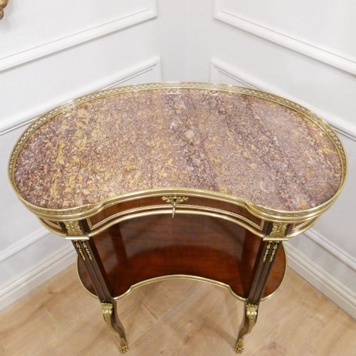 fig 4. A French Louis XVI style kidney-shaped mahogany side table featuring a marble top, pierced brass gallery, lower undertier, and elaborate gilt-bronze mounts.