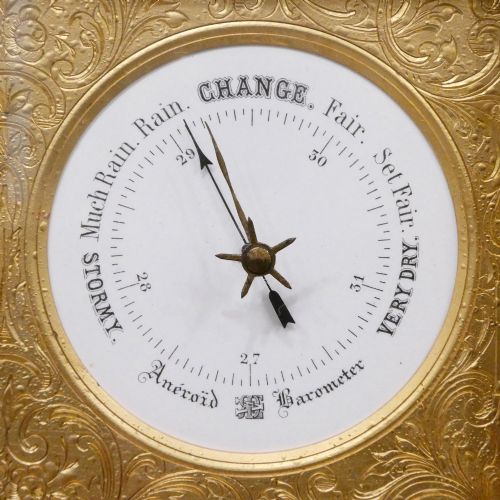 fig 3. An Edwardian rectangular ebonised wooden mantel clock and barometer unit with twin white circular dials set into a scroll-engraved brass plate.