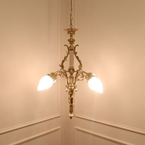 fig 1. A French Neoclassical style gilt bronze chandelier featuring a central lyre-shaped stem and two outward-curving arms with frosted glass shades.