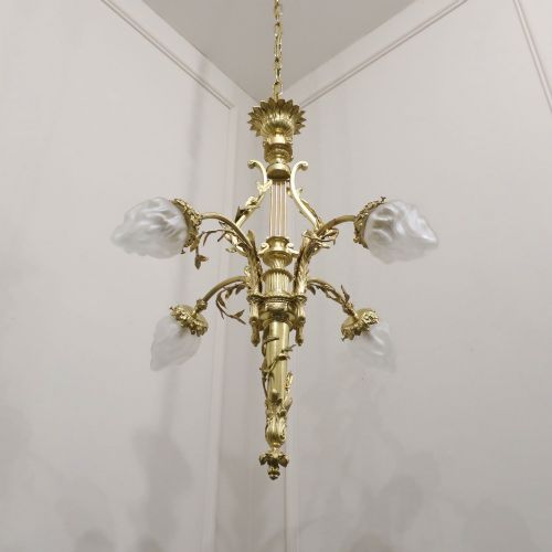 fig 2. A French Neoclassical style gilt bronze chandelier featuring a central lyre-shaped stem and two outward-curving arms with frosted glass shades.