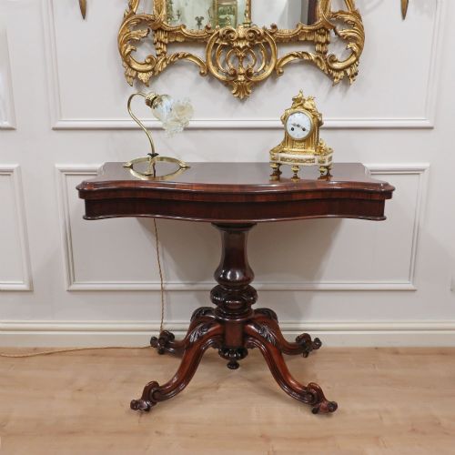 fig 1. A Victorian rosewood side table featuring a serpentine fold-over top mounted on a central carved pedestal with four scroll-footed legs.