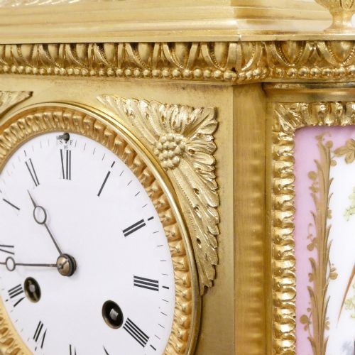 fig 3. An antique French gilt bronze mantel clock featuring hand-painted pink porcelain panels, a porcelain urn finial, and an enamel dial with Roman numerals.