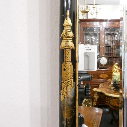 fig 1. An arched wall mirror with a dark lacquered frame featuring gilded Chinoiserie motifs and segmented glass plates.
