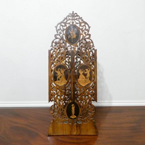 fig 2. A fretted walnut triptych dressing table mirror featuring central oval glass plates surrounded by openwork carved scroll patterns and inlaid timber panels.