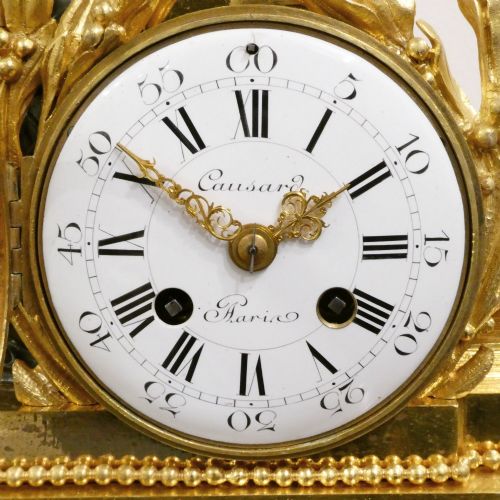fig 1. A 19th-century French gilt bronze mantel clock featuring a dark patinated bronze cherub seated beside a circular enamel dial atop a gilt relief base.
