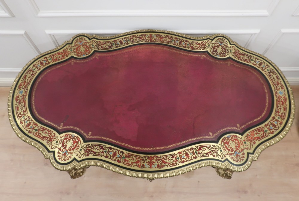 A French Louis XV style Boulle bureau plat writing desk featuring brass marquetry inlay, red leather surface, gilt bronze mounts, and cabriole legs. View II