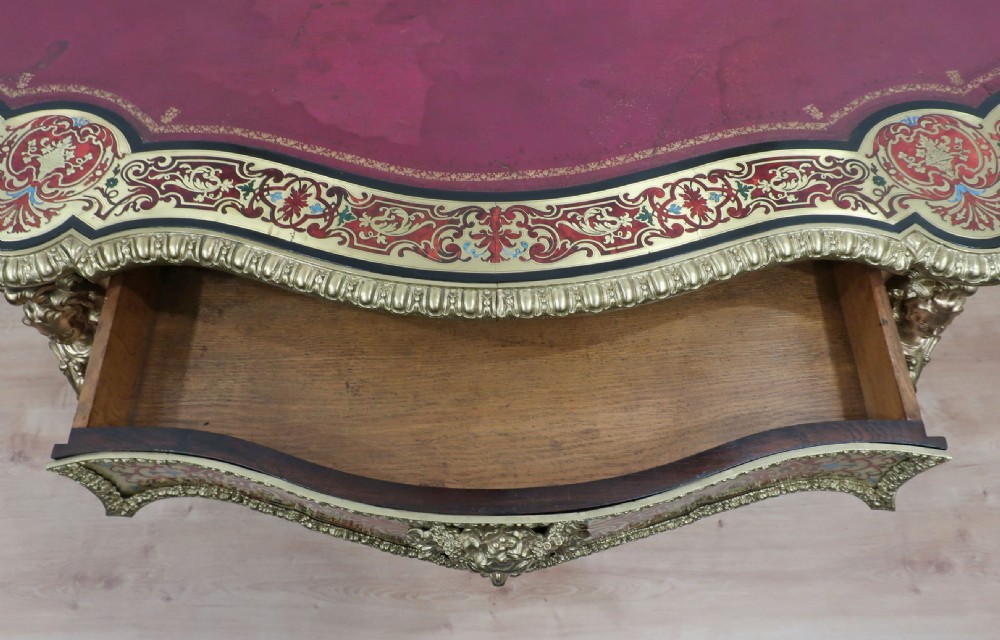 A French Louis XV style Boulle bureau plat writing desk featuring brass marquetry inlay, red leather surface, gilt bronze mounts, and cabriole legs. View VIII