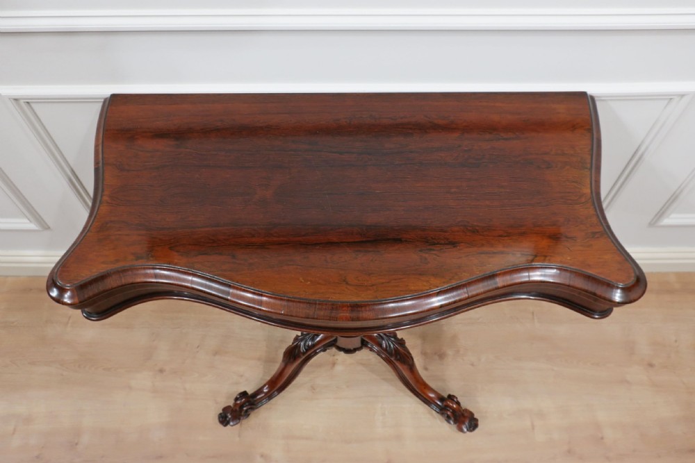 A Victorian dark brown rosewood side table featuring a serpentine top, central turned column, and four carved scroll legs. View III