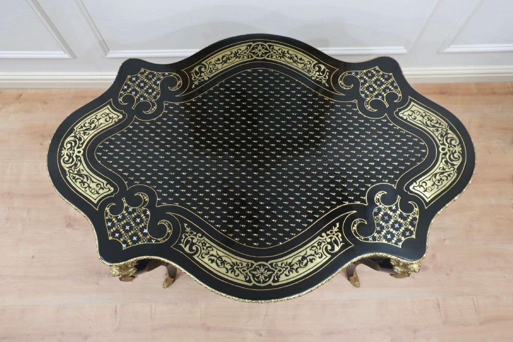 An ebonised French centre table decorated with brass marquetry inlay, gilt-bronze mounts, and cabriole legs. View V