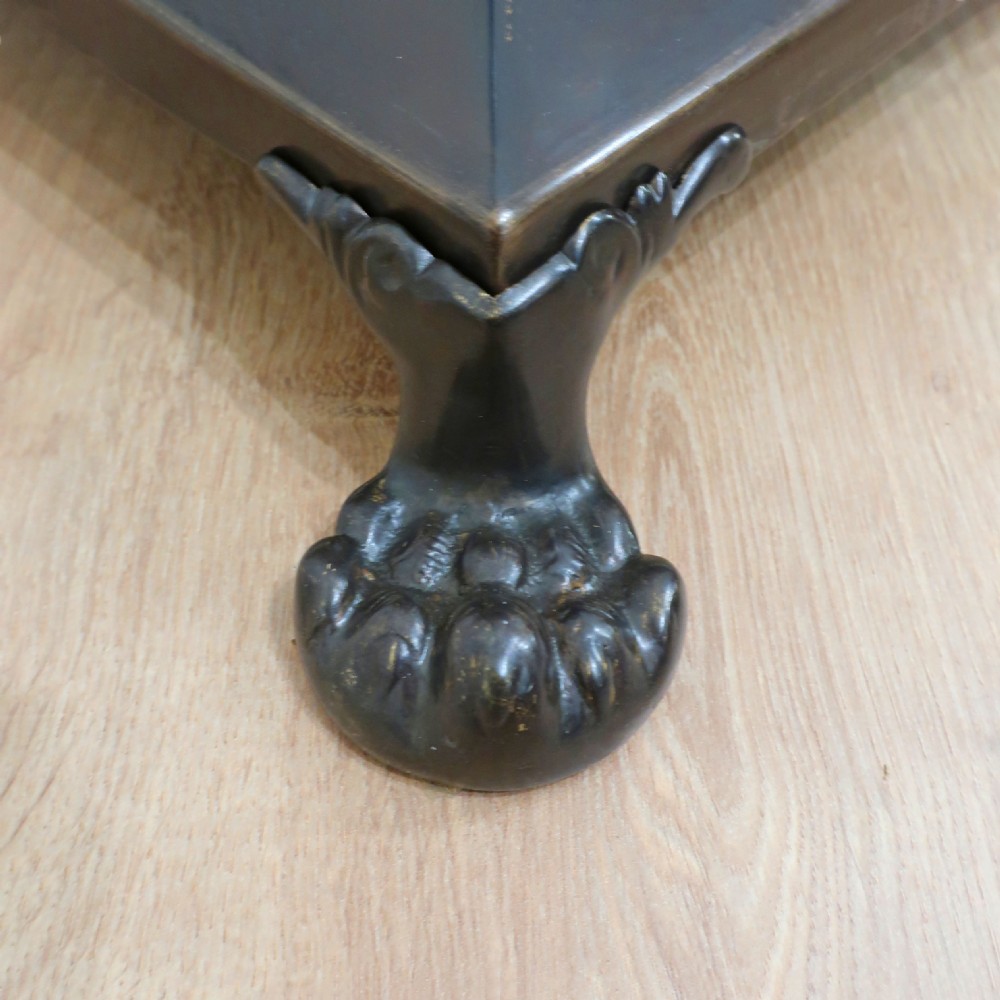 An Edwardian bronzed floor lamp with a pleated cream lampshade, reeded central column, and a stepped square base supported by claw feet. View VII