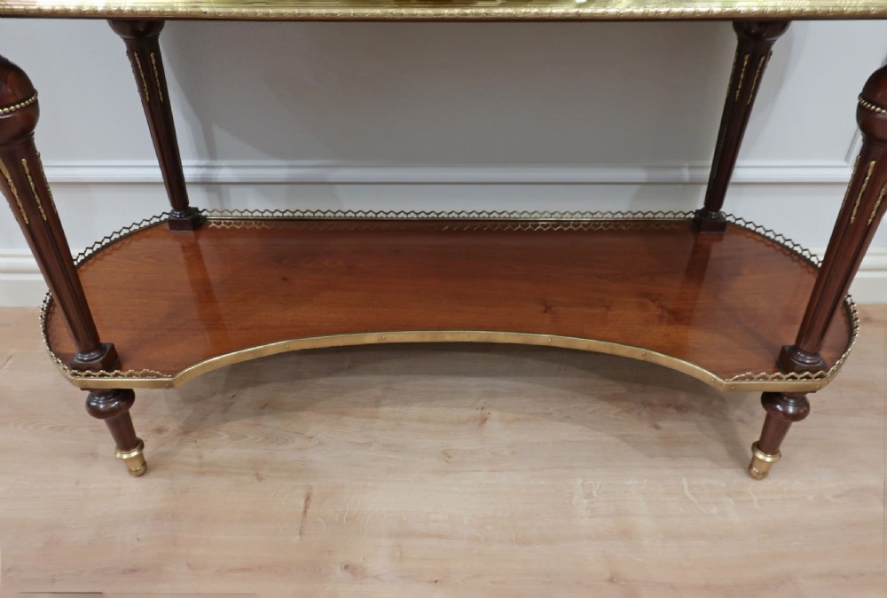 An early twentieth-century French style mahogany display cabinet featuring glazed doors, brass gallery rails, turned legs, and a lower tier. View XII
